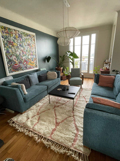 Modern living room with blue sofas, a coffee table, and decorative elements.